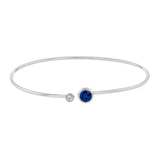 This understated white gold bangle features a subtle .08 ctw white diamond accent opposite a stunning .71 ctw sapphire. Perfect for stacking.