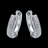 Our statement making oval diamond huggie earrings in 18K white gold, sparkle with 3 rows of diamonds and have a bar-snap closure