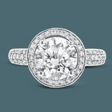 This classically-styled white gold engagement ring features a circular halo and is highlighted by .43 ctw of sparkling round cut white diamonds.