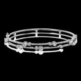 This whimsical bangle in 18K white gold features 1.80 ctw of bezel set diamonds, that appear to be suspended on a wire